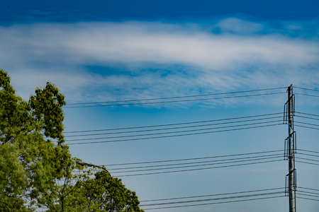 blue sky on sunny day with high voltage electric power supply poleの写真素材