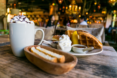 A plate of waffle with banana, whipping cream, blueberry and syrup, delicious, yummyの写真素材