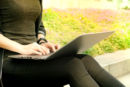 A student woman is typing on laptop computerの写真素材