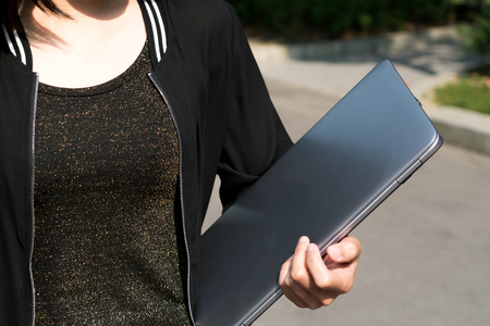 A student woman is holding laptop computerの写真素材