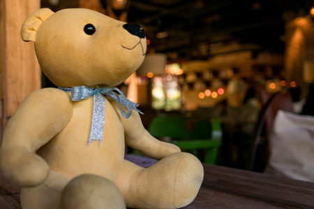 a little light brown cute bear sitting on the wooden tableの写真素材