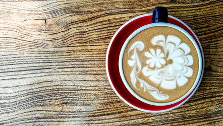 Hot mocha coffee or capuchino in the green cup with luxury pattern on the wooden tableの写真素材