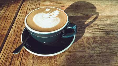 Hot mocha coffee or cappuccino in the blue cup with luxury pattern on the wooden tableの写真素材