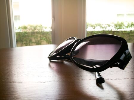 under expose of fashion sunglasses on the wooden tableの写真素材
