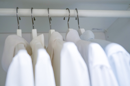 row of men and women shirts on the hanger, hanging in the wardrobeの写真素材