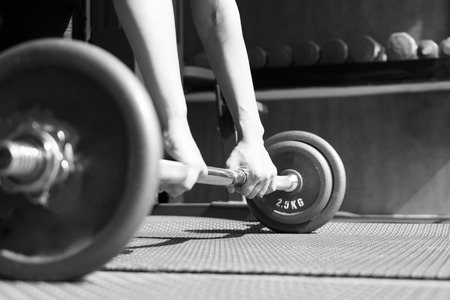 black and white image of women hand lifting the steel dumbbell in a gym musclebuildingの写真素材
