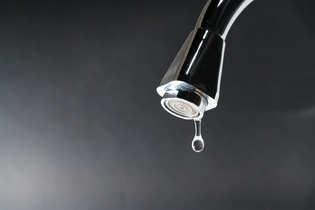water drop on faucet with  black backgrounds, world water day conceptの写真素材