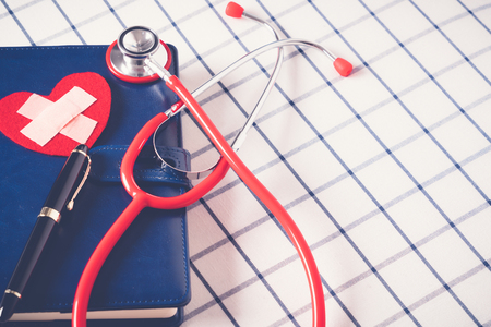 World health day healthcare and medical concept red stethoscope and red heart shape on the blue daily notebookの写真素材
