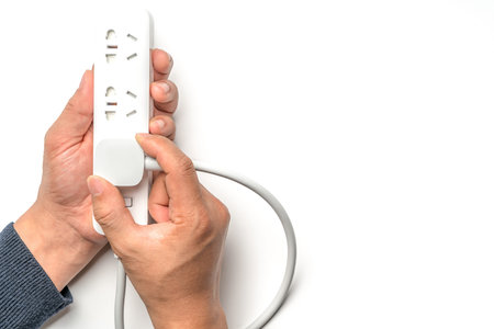 man hand plugging the electric power socket bar white color isolate. save energy and reduce energy...