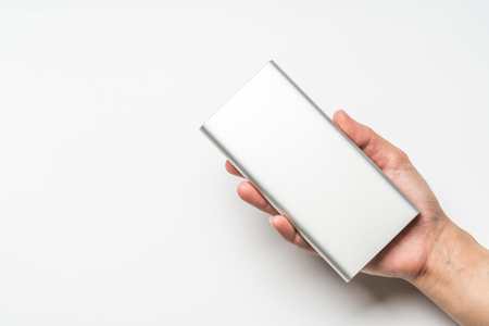 white silver power bank on hand isolate. save energy and reduce energy efficiency conceptの写真素材