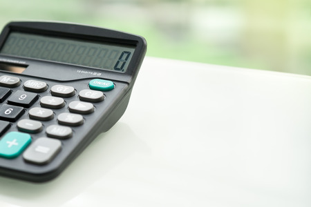Calculator on the white table near window, closeup sideview isolatedの写真素材