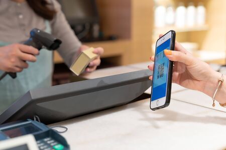 SHANGHAI, CHINA - MAY, 2018 : Qr code payment, online shopping, cashless technology concept. women hand hold the smartphone for payment at shopping centerのeditorial素材