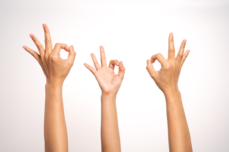 women hand OK sign gesturing on white background in three actionの写真素材