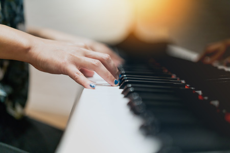 women hand on classic Piano keyboard closeupの写真素材