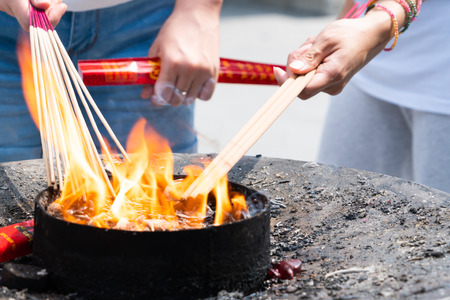 Lighting the candle pray to Buddha at Longhua temple in Shanghai, Chinaの写真素材