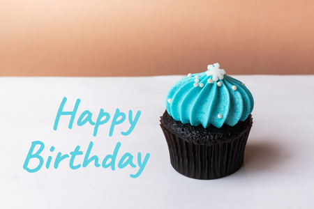 Happy Birthday cute cupcake with small white snow blue cream on white backgroundの写真素材