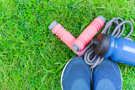 Jump rope, Running shoes, and drink bottle on grass backgroundの写真素材