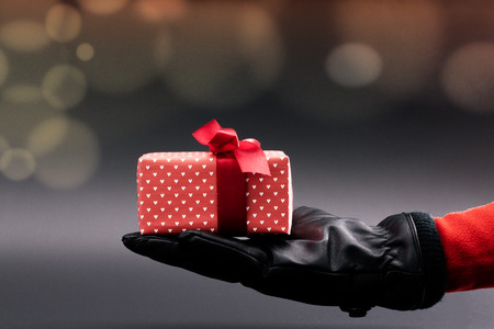 Woman hand give a present on black background, Christmas Boxing Day conceptの写真素材