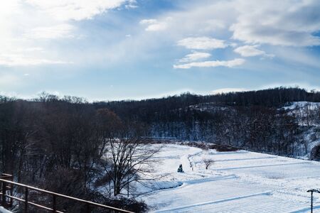 lawn covered with white snow in frosty winter day with blue skyの写真素材
