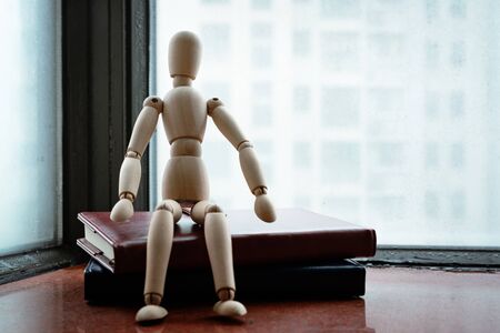 Woodman sitting on book after hard work on rainy dayの写真素材