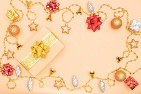 gift box or present box with golden star, bell and ball on golden background for birthday, christmas or wedding ceremonyの写真素材