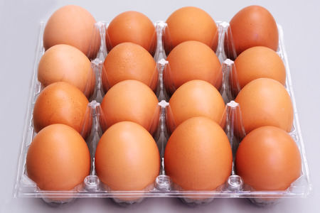 brown chicken eggs in plastic box on gray background, easter festive conceptの写真素材