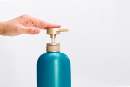 women hand apply hair shampoo conditioner bottle on white background. Beauty And Body Care Conceptの写真素材