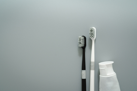 couple of toothbrush with toothpaste on gray backgroundの写真素材