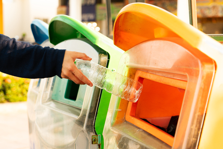women hand throwing away the garbage to the bin/trash, sorting waste/garbage before drop to the binの写真素材