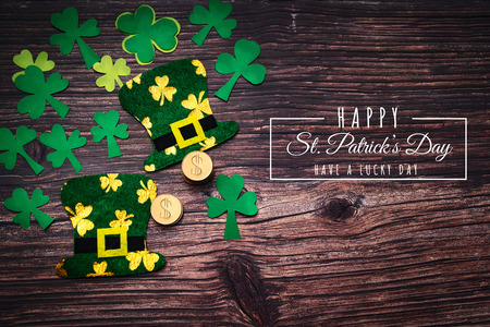 St Patricks Day, golden coins, festive hat and green Shamrocks with saint patricks day lettering on woodenの写真素材