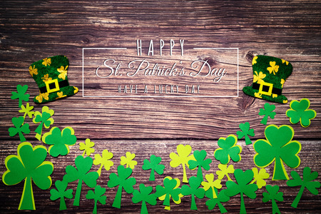 St Patricks Day, golden coins, festive hat and green Shamrocks with saint patricks day lettering on woodenの写真素材