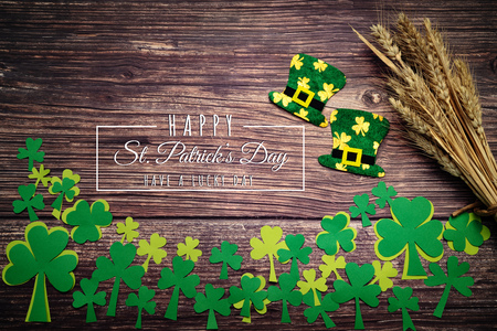 St Patricks Day, golden coins, festive hat and green Shamrocks with saint patricks day lettering on woodenの写真素材