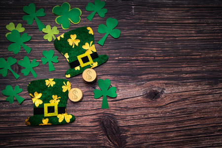 St Patricks day, golden coins, festive hat and green Shamrocks on woodenの写真素材