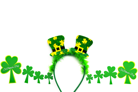 St Patricks day, festive leprechaun hat on headband and green Shamrocks on white backgroundの写真素材
