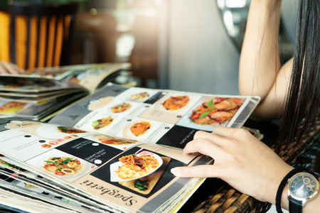 young women looking menu at restaurant, selective focus on menuの写真素材
