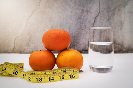Fresh fruit for diet, measuring tape and drinking water on grunge background. Concept of diet and healthy lifestyleの写真素材