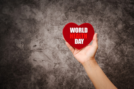 World health day, women hand hold red heart  on grunge black backgroundの写真素材
