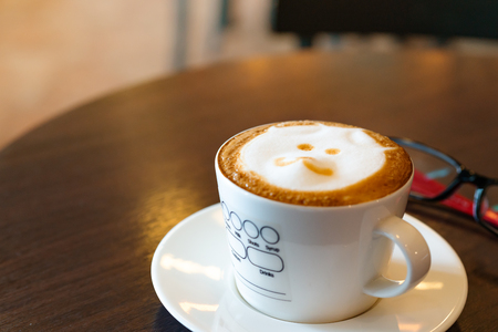 hot coffee on wooden table with eye glassesの写真素材