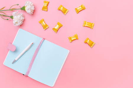 workspace desk styled design office supplies, candy and flower on pink pastel background minimal styleの写真素材