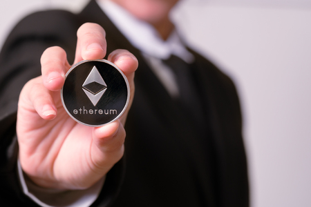 cryptocurrency coins - Ethereum, Litecoin, Bitcoin, Ripple. Women hold the cryptocurrency coin on hand. Physical bitcoins gold and silver coinsの写真素材