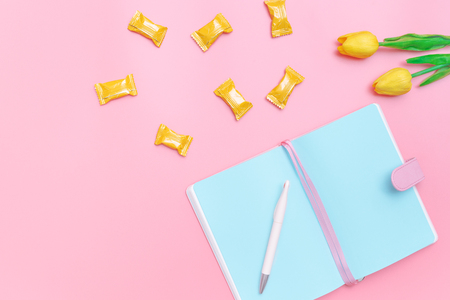 workspace desk styled design office supplies, candy and flower on pink pastel background minimal styleの写真素材