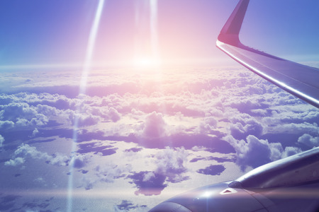Wing of the plane on blue skyline and cloudscape, view of the airplane windowの写真素材