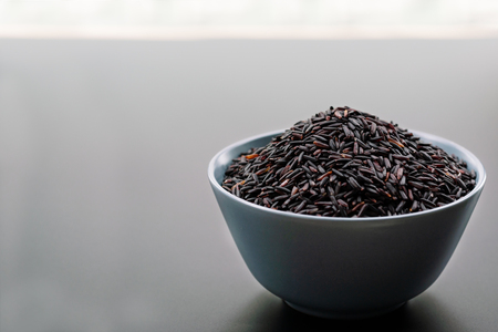 bowl of jasmine black rice on black backgroundの写真素材