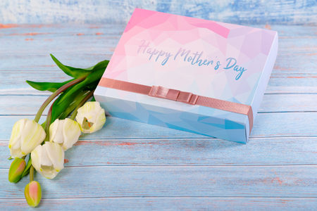 Happy mother's day concept. Gift box and flower on wooden tableの写真素材