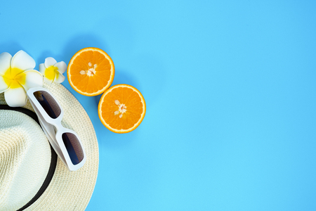 Beautiful summer holiday, Beach accessories, sunglasses, hat and orange on blue backgroundの写真素材