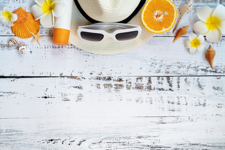 Beautiful summer holiday, Beach accessories, orange, sunglasses, hat and shells on wooden backgroundの写真素材