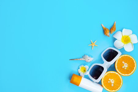 Beautiful summer holiday, Beach accessories, orange, shells and sunblock on blue backgroundの写真素材