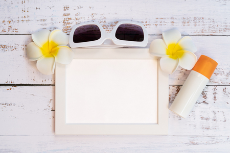 Beautiful summer holiday, Beach accessories, orange, sunglasses, flower and photo frame on wooden backgroundの写真素材