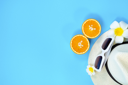 Beautiful summer holiday, Beach accessories, sunglasses, hat and orange on blue backgroundの写真素材