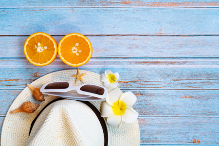 Beautiful summer holiday , Beach accessories, sunglasses, hat and orange on wooden backgroundの写真素材